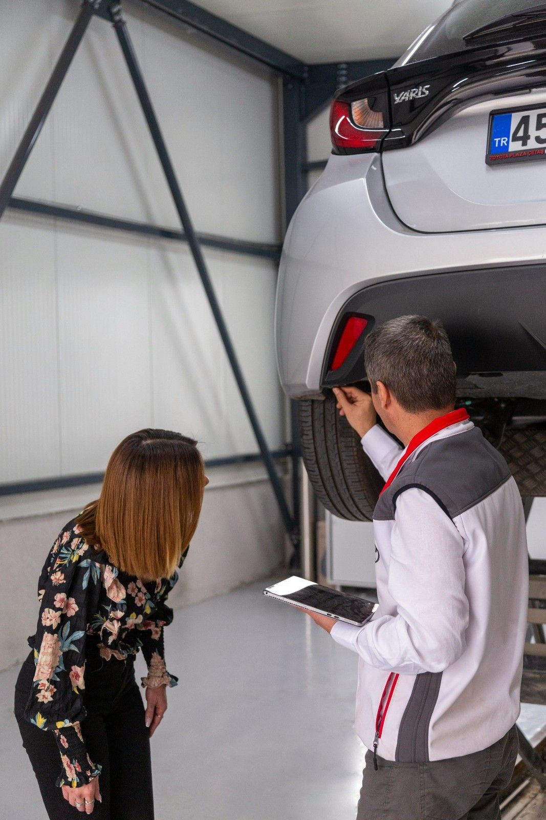 Ein Mann und eine Frau schauen unter ein Auto