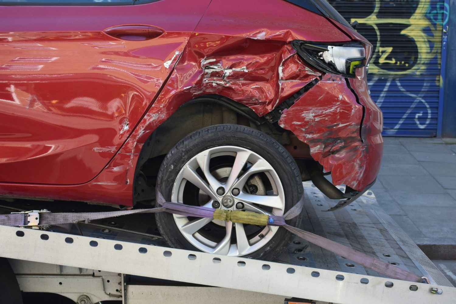 Ein rotes Auto befindet sich auf einem Abschleppwagen mit Ladefläche.