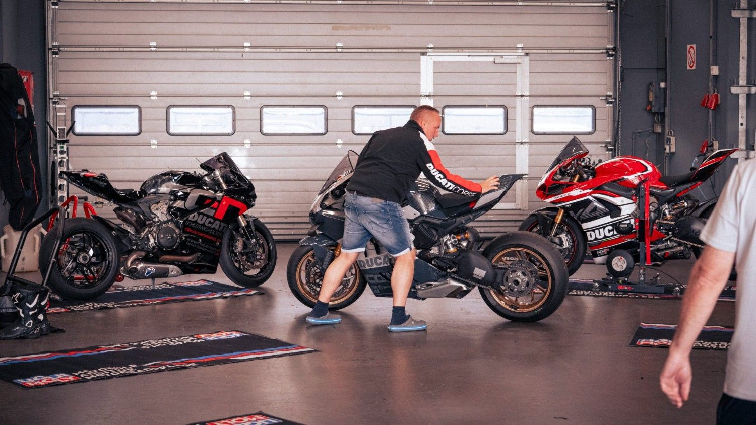 Ein Mann reinigt ein Motorrad in einer Garage.
